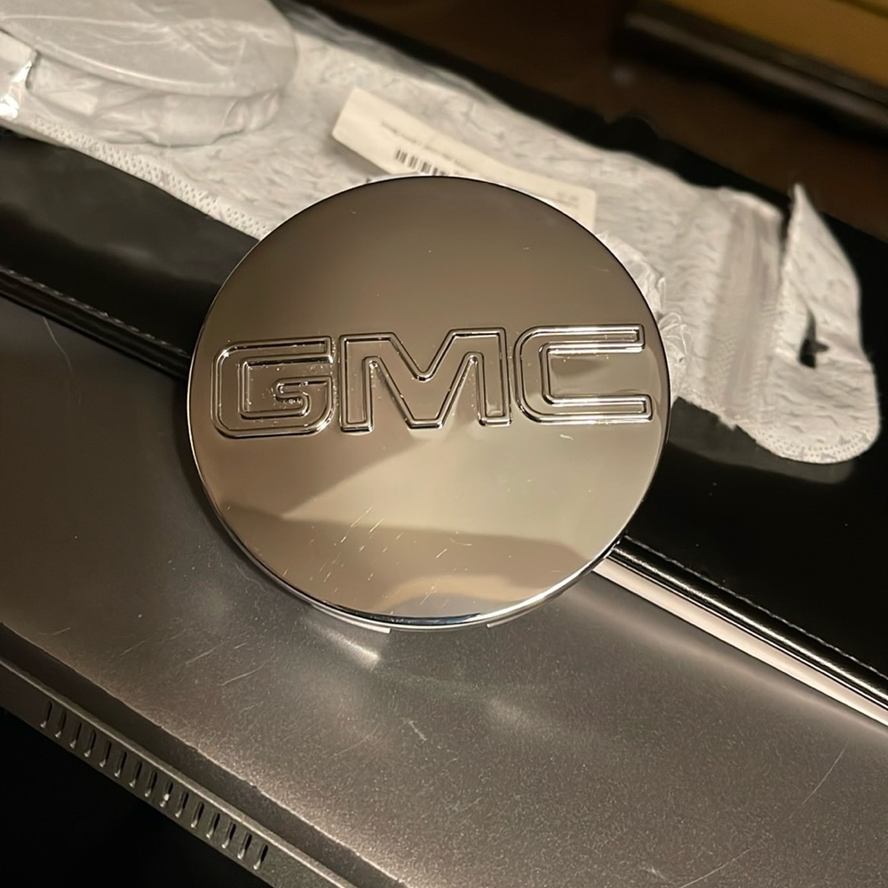 Gee… it’s a Set of GMC tire caps. New in pkg. Never installed.